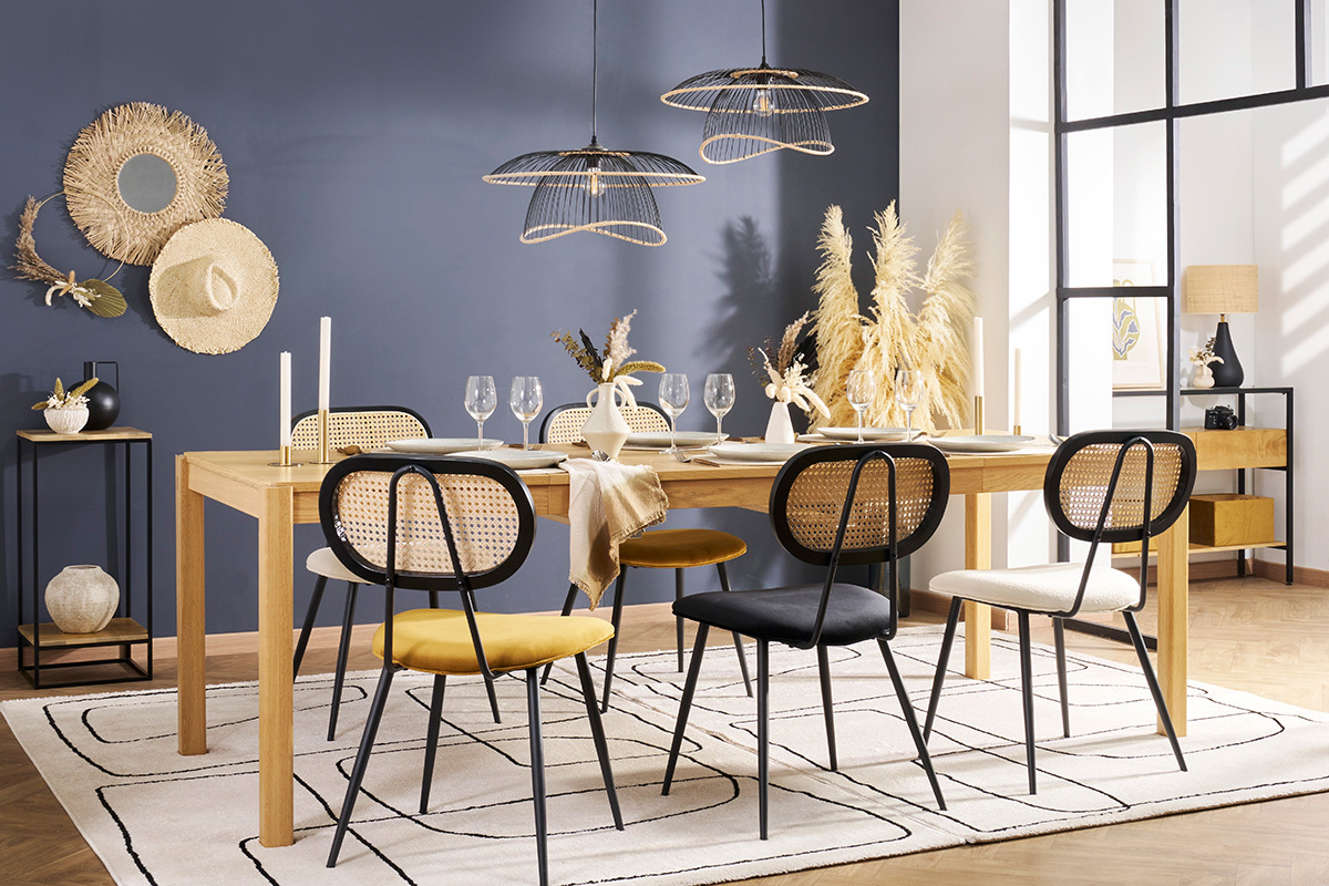 Sillas de dise�o en terciopelo y rat�n alrededor de una mesa de madera clara.