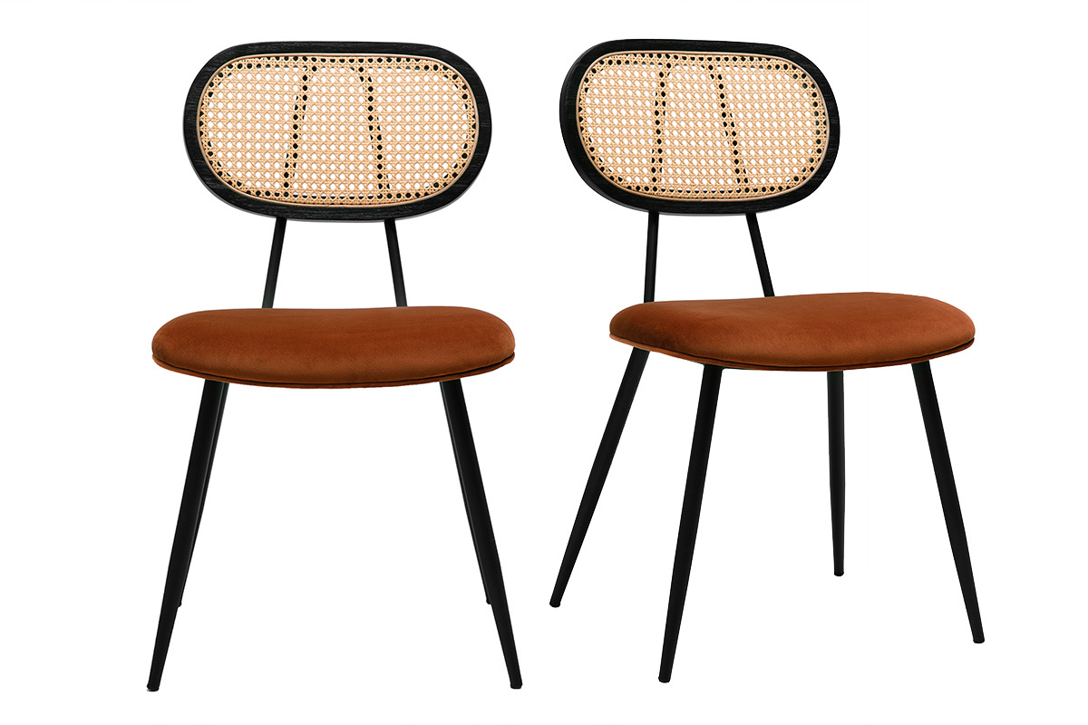 Dos sillas de terciopelo color tierra quemada, respaldo de rat�n, patas de metal negro, vista frontal.