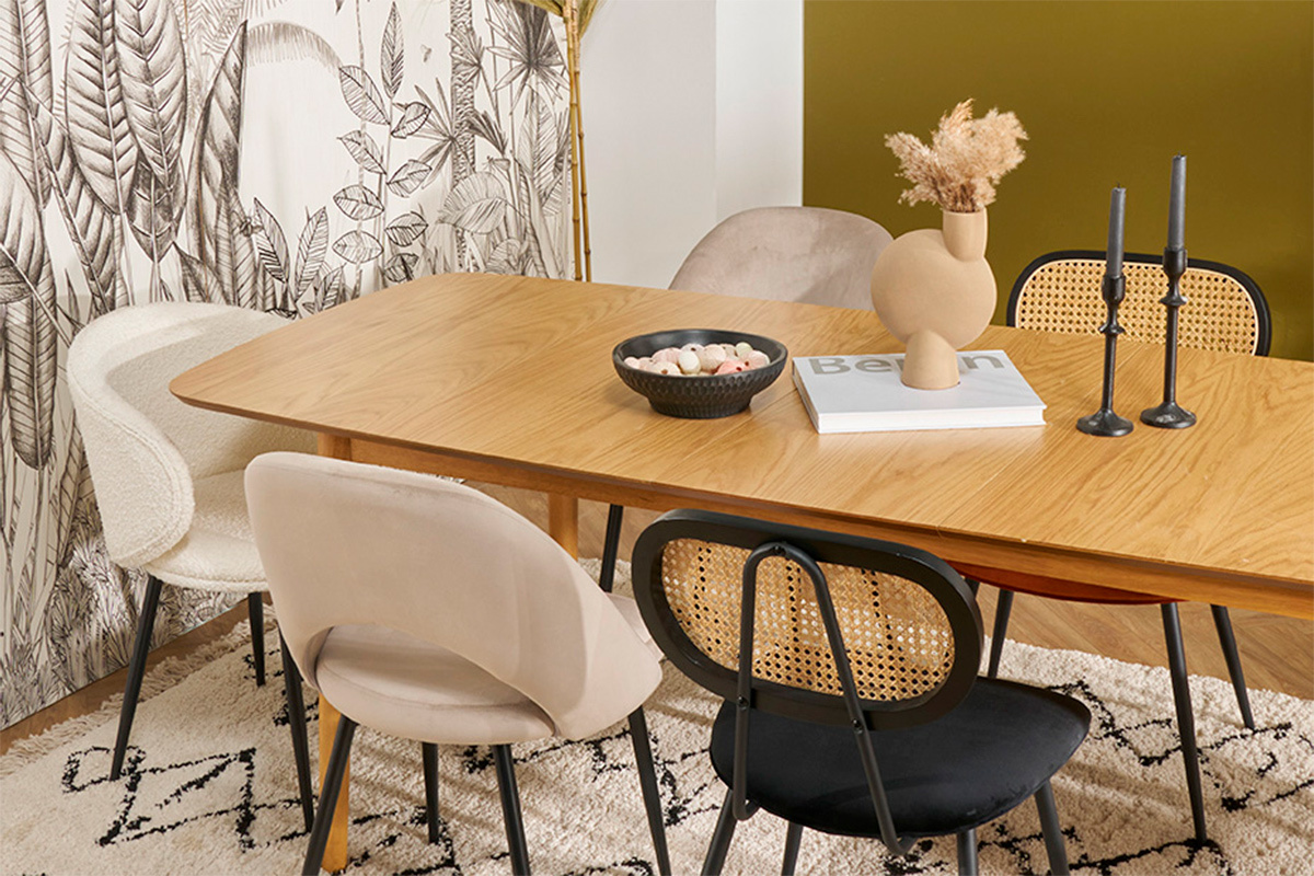 Sillas de dise�o en terciopelo y rat�n alrededor de una mesa de madera clara.