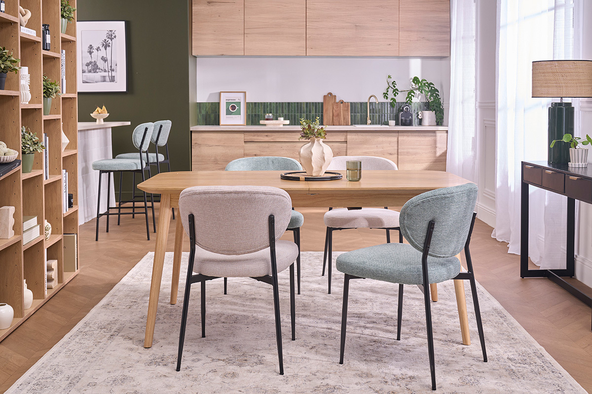 Sillas verdes celad�n y metal negro alrededor de una mesa de madera, en un comedor moderno.