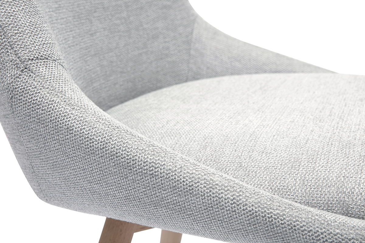 Detalle de una silla gris claro en tela efecto terciopelo texturado con patas de madera clara.