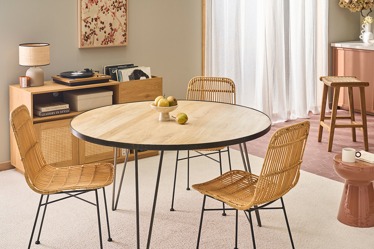 Sillas de rat�n y metal negro alrededor de una mesa redonda de madera.