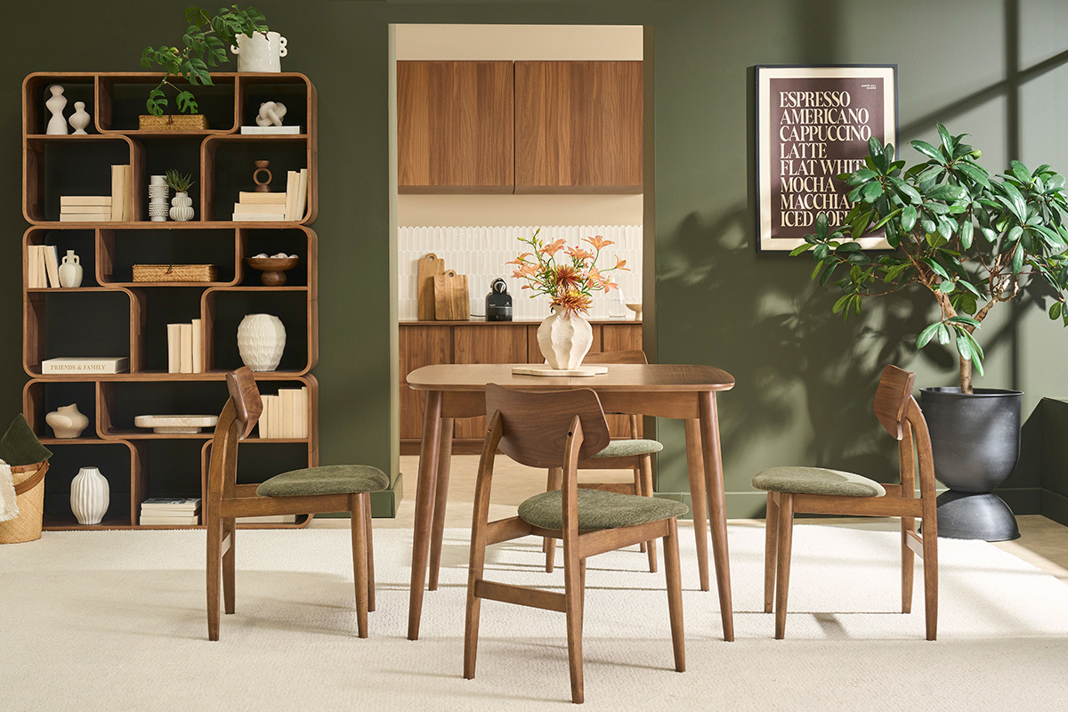 Sillas escandinavas de madera oscura y tejido de terciopelo verde caqui alrededor de una mesa en un interior moderno.