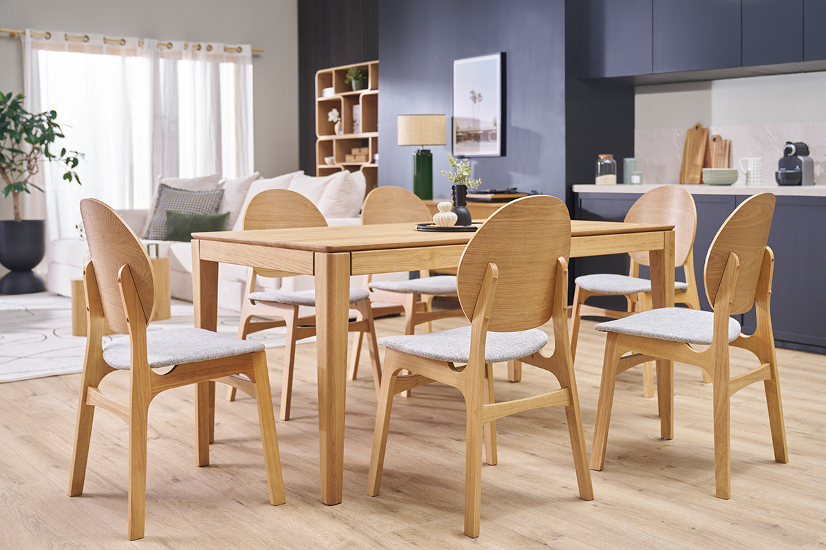 Sillas escandinavas ELTON de madera clara y tela gris claro alrededor de una mesa de comedor, vista en 3/4