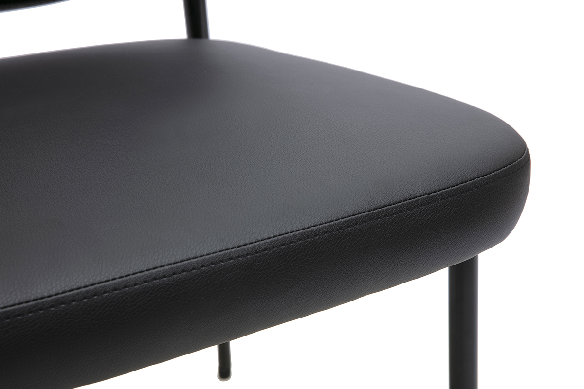 Primer plano del asiento negro de poliuretano de una silla BREKA con patas de metal.