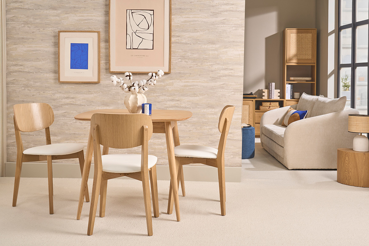 Sillas vintage LUCIA de madera clara y asiento blanco, delante de una mesa en una decoraci�n escandinava.