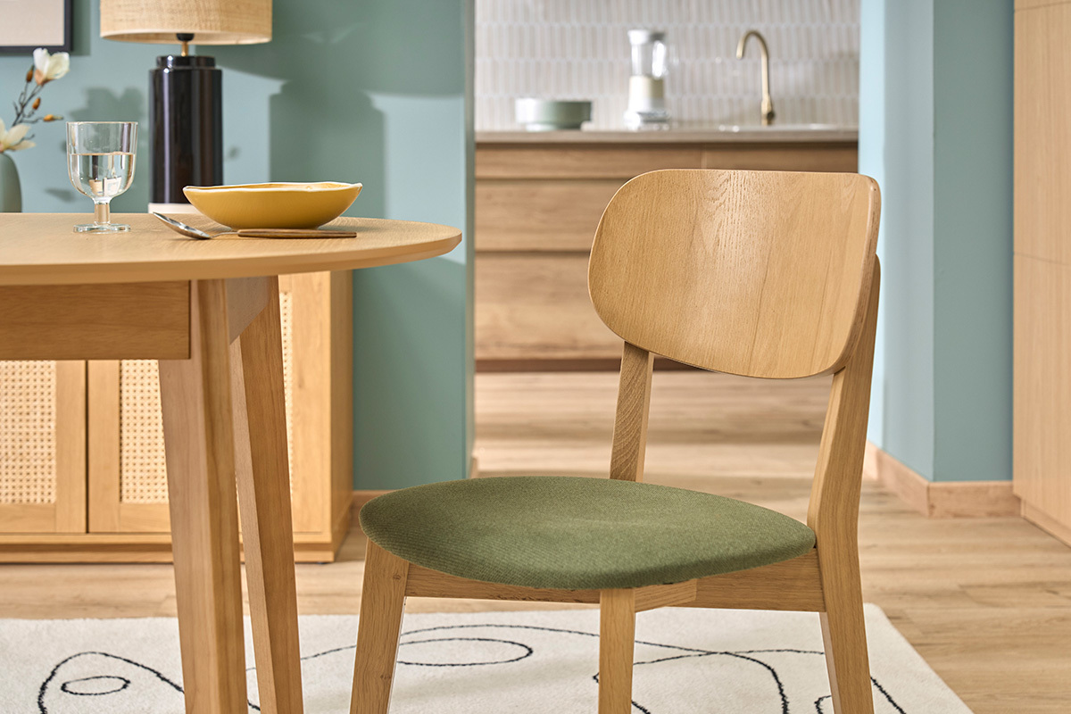 Silla vintage LUCIA de madera clara y tejido verde caqui, vista lateral junto a una mesa