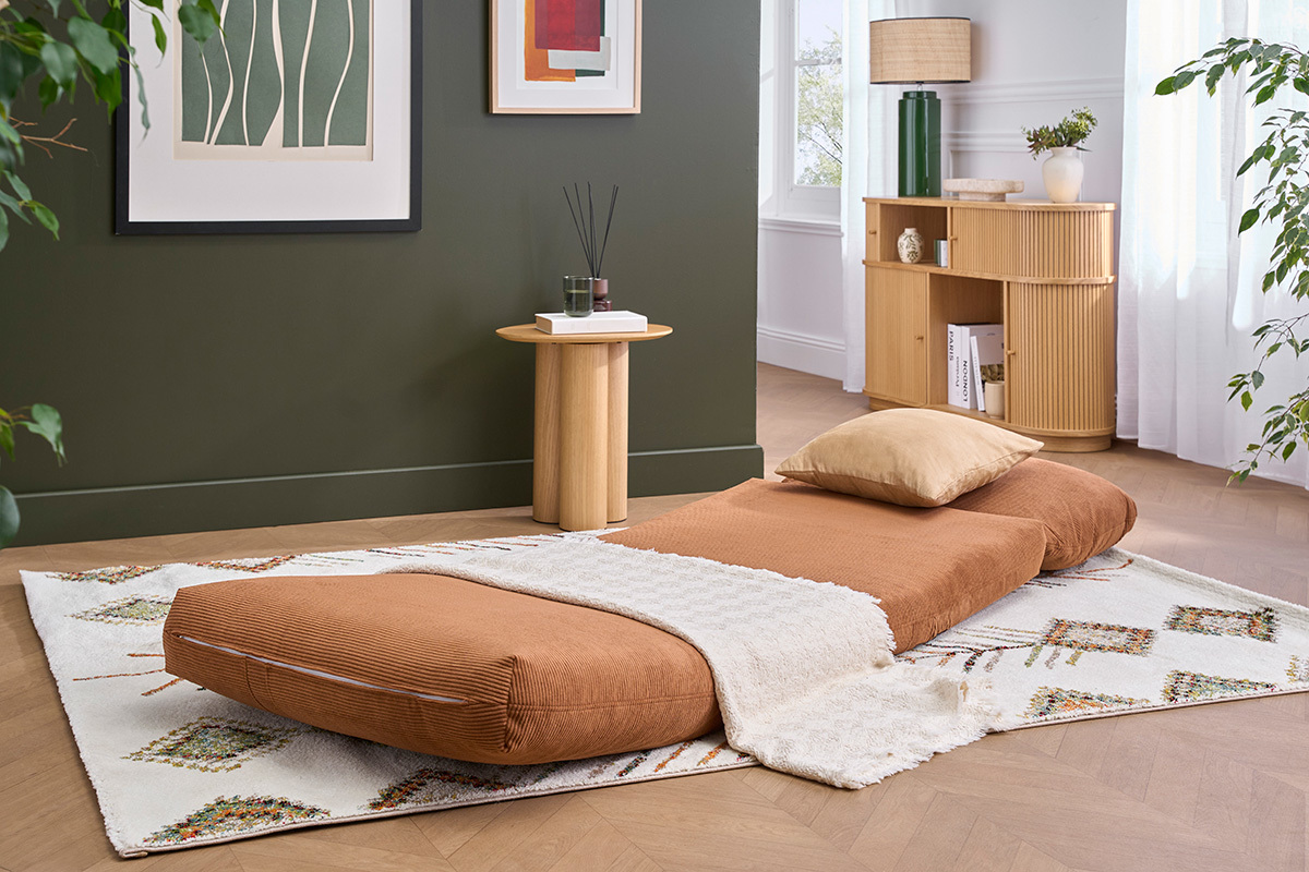 Sill�n SPENCER de tela de terciopelo acanalado color tierra quemada, desplegado en una sala con decoraci�n.