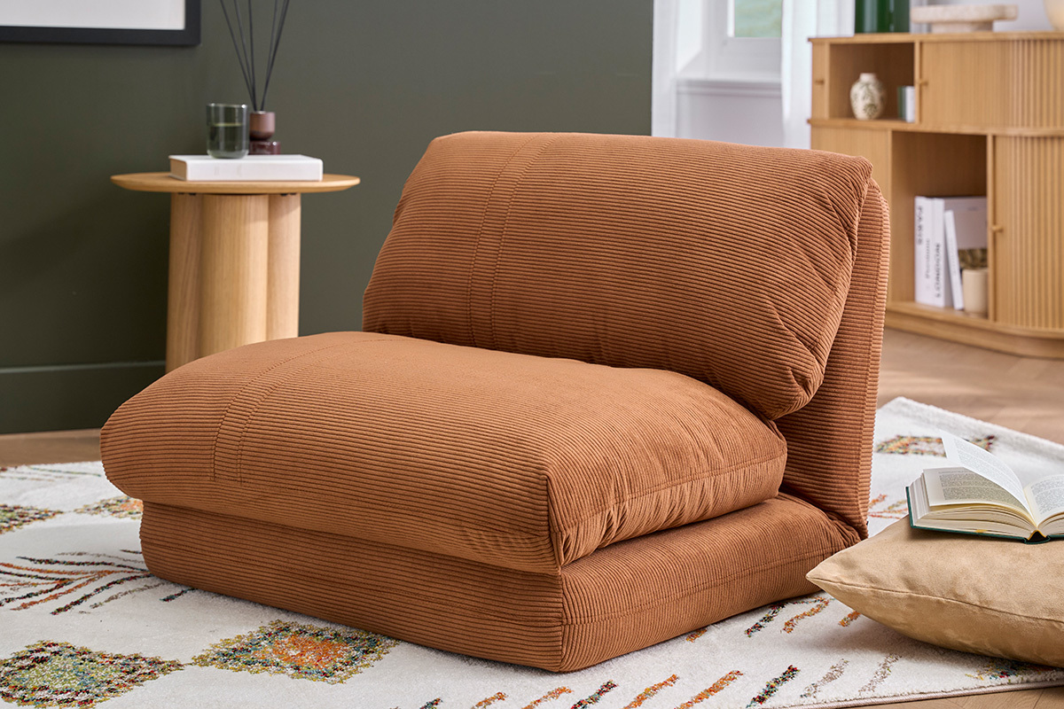 Sill�n SPENCER en tela de terciopelo acanalado color tierra quemada, vista de tres cuartos, sobre una alfombra en un sal�n.