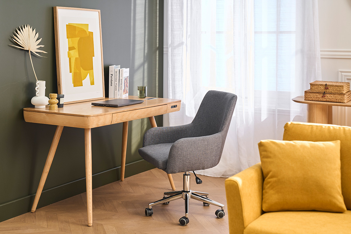 Silla de oficina gris SHANA con ruedas, frente a un escritorio de madera, vista en �ngulo.