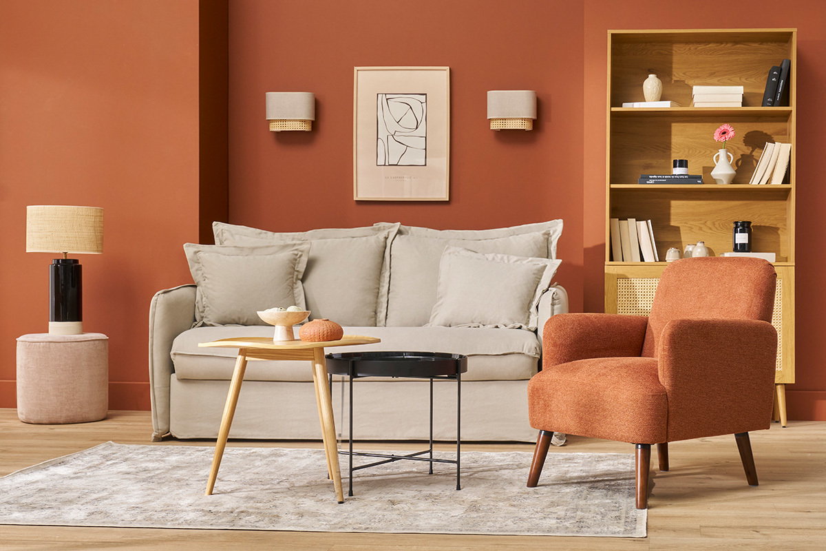 Sala con sof�, sill�n de tela naranja, mesa baja de madera y estanter�a.