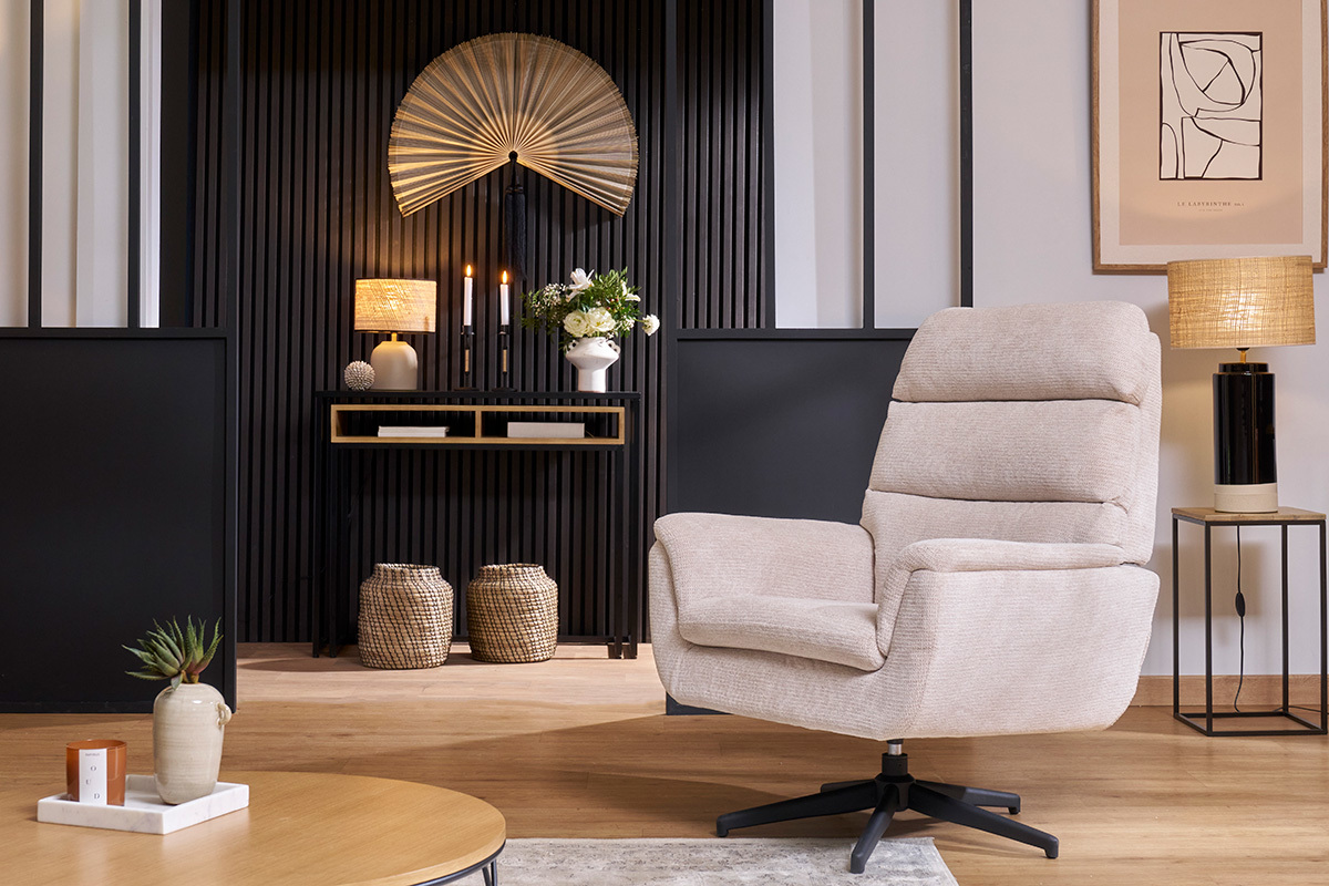 Sill�n giratorio beige de tela chenilla con base de metal negro, en un sal�n elegante.