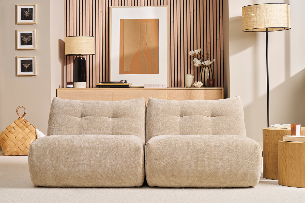 Sala con dos sillones lounge BUMPY de terciopelo topo frente a un mueble de madera.