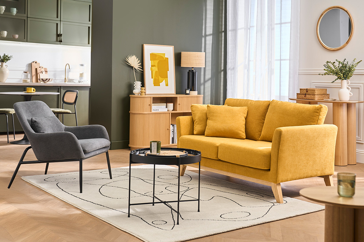 Sill�n gris oscuro de tela efecto terciopelo con patas de metal negro, en un sal�n moderno.