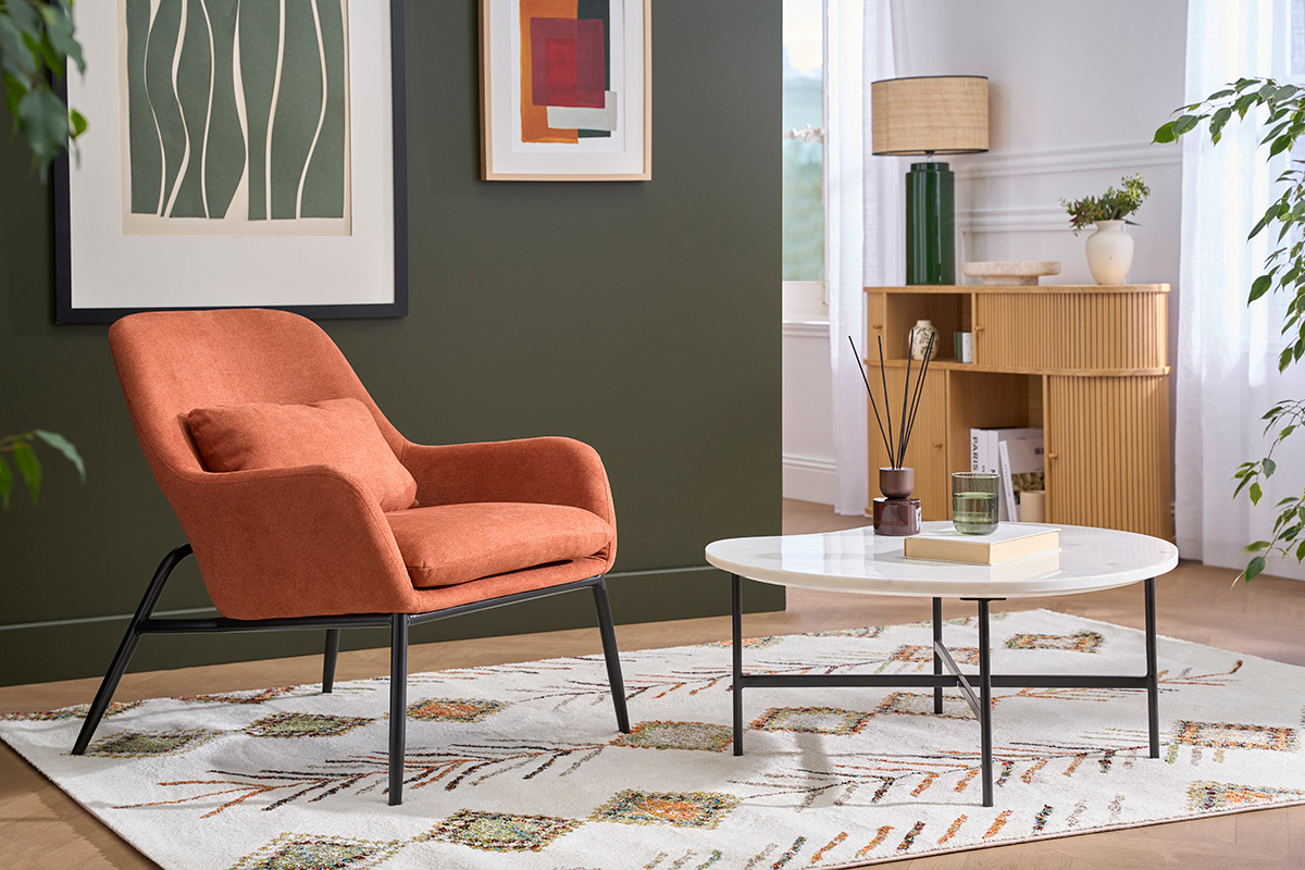 Sill�n de dise�o tierra quemada, tela efecto terciopelo, patas de metal negro, vista lateral en un sal�n moderno.