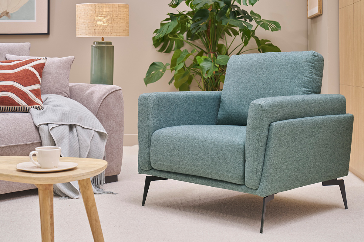 Sill�n de dise�o verde gris�ceo MOSCO con estructura de metal negro, visto en un sal�n.