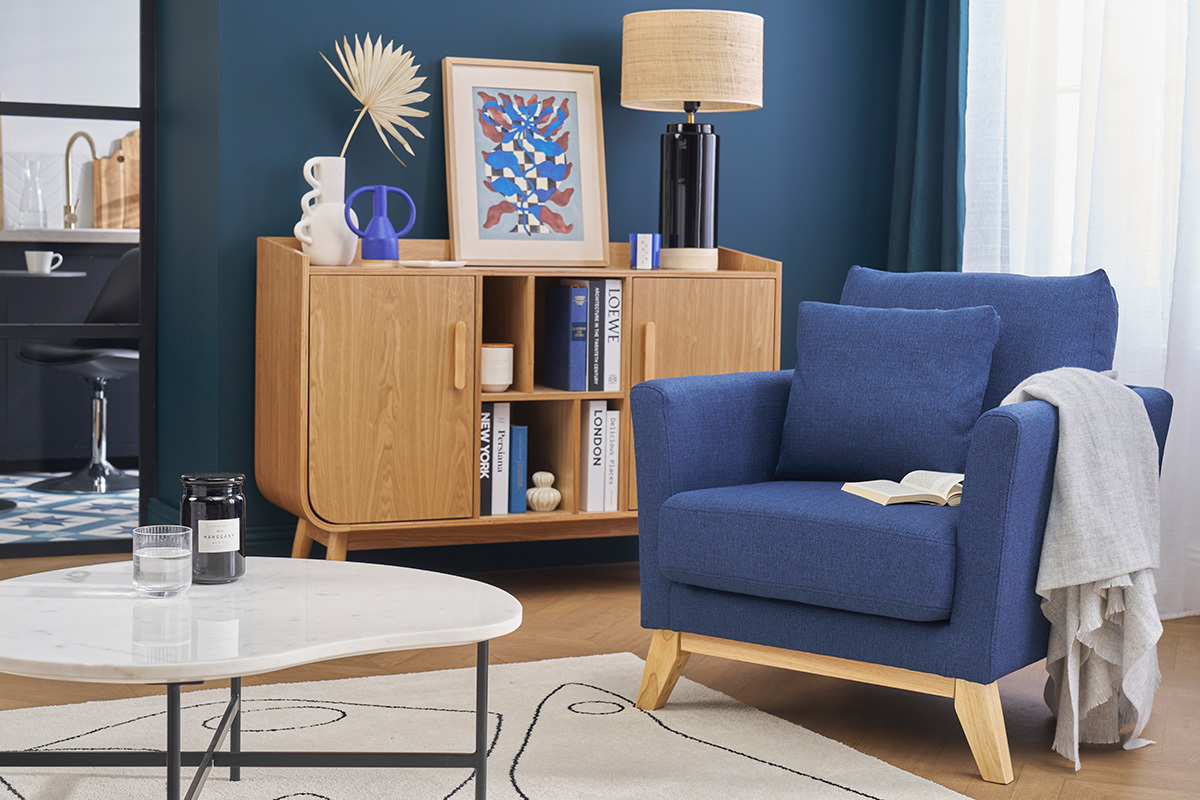 Sill�n escandinavo azul oscuro y madera clara en una sala moderna.