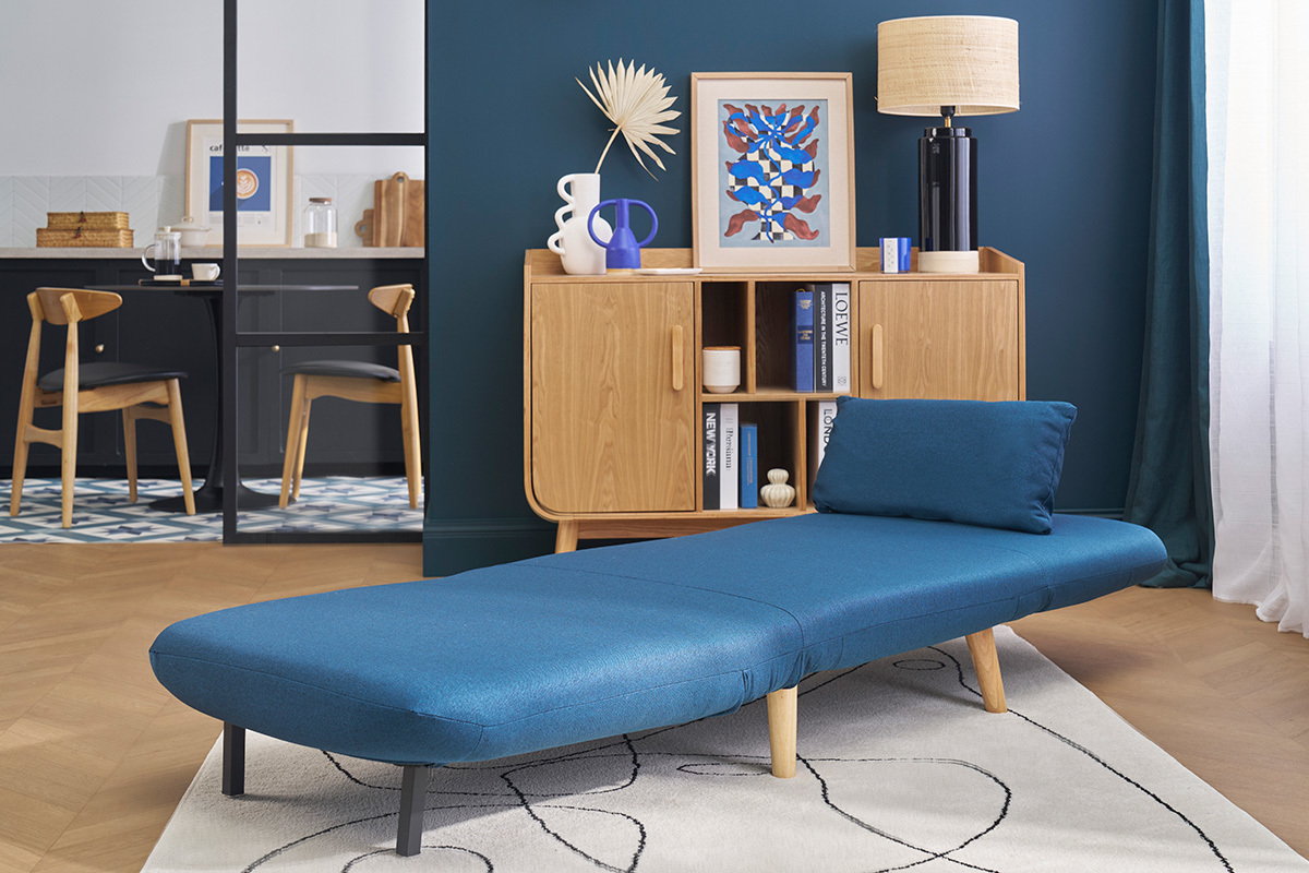 Sill�n convertible azul oscuro AMIKO desplegado en un sal�n escandinavo.