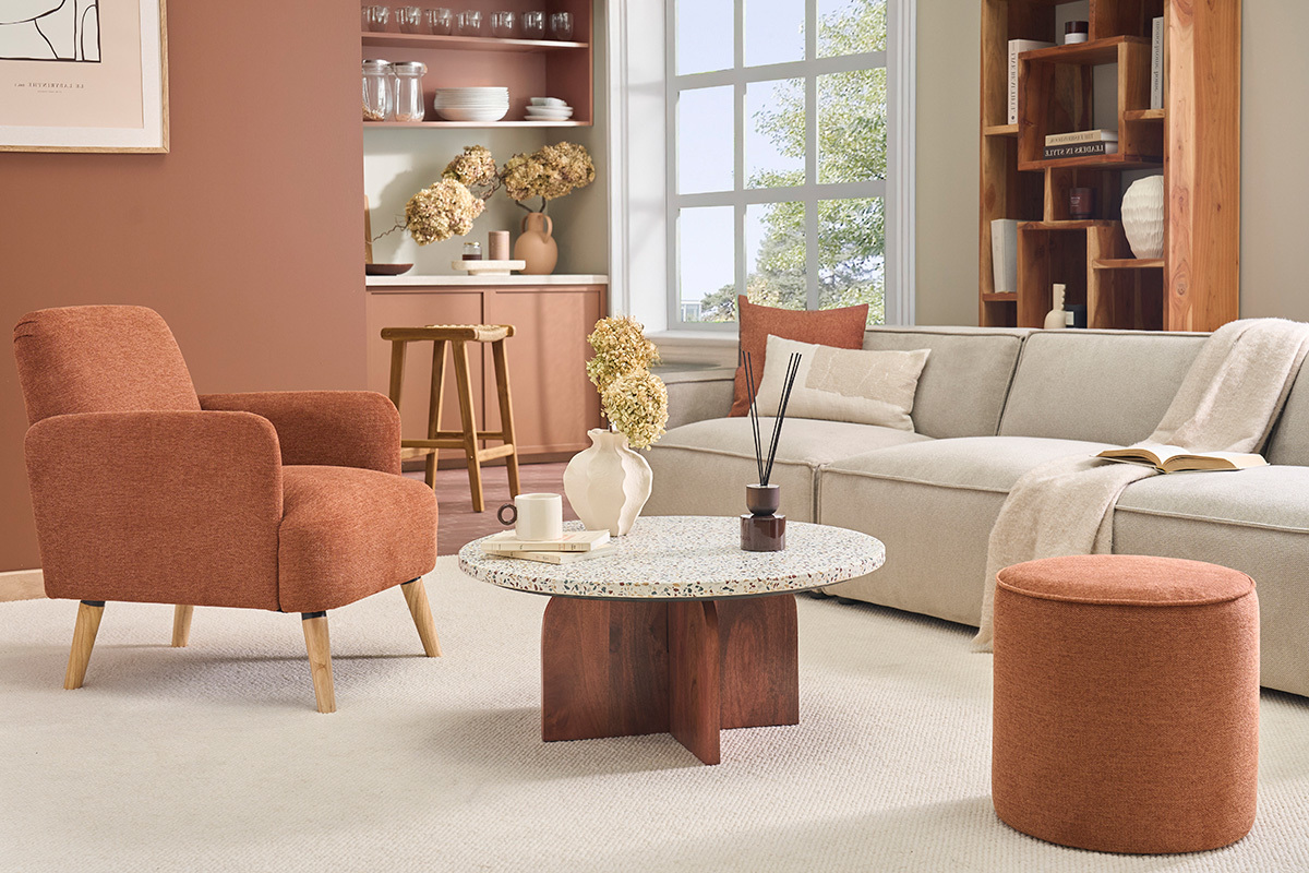 Sill�n escandinavo de tela color tierra quemada y madera clara en un sal�n.