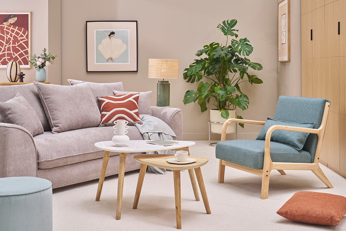 Sill�n verde gris�ceo y madera clara DERRY en un sal�n escandinavo con sof�, mesas y plantas.