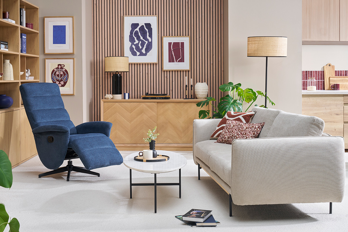 Saln con silln giratorio relax en tela azul y sof claro.