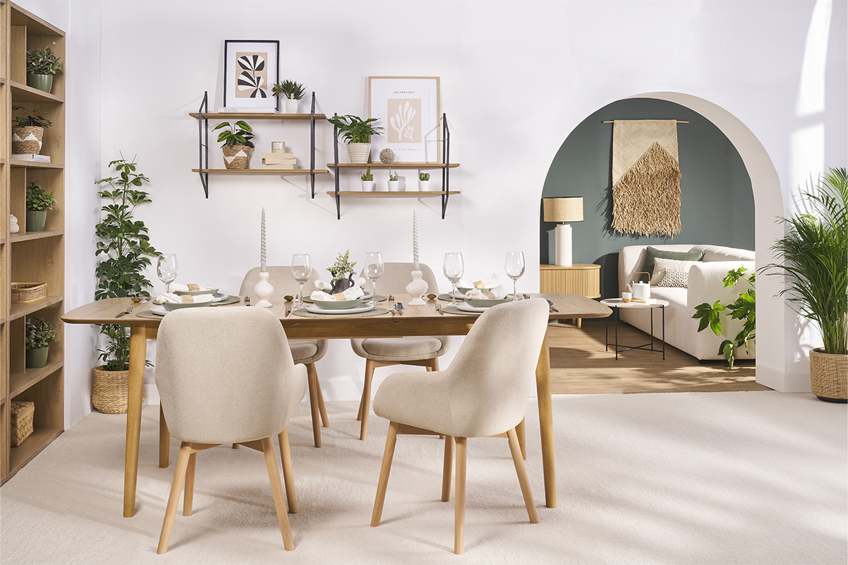 Comedor con sillas escandinavas beige de tela y patas de madera clara alrededor de una mesa.