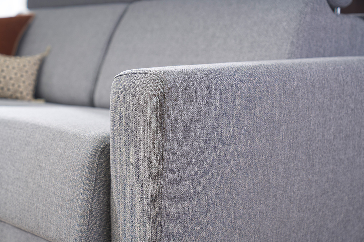 Detalle del brazo de un sof� cama GOYA en tejido gris con reposacabezas ajustables.