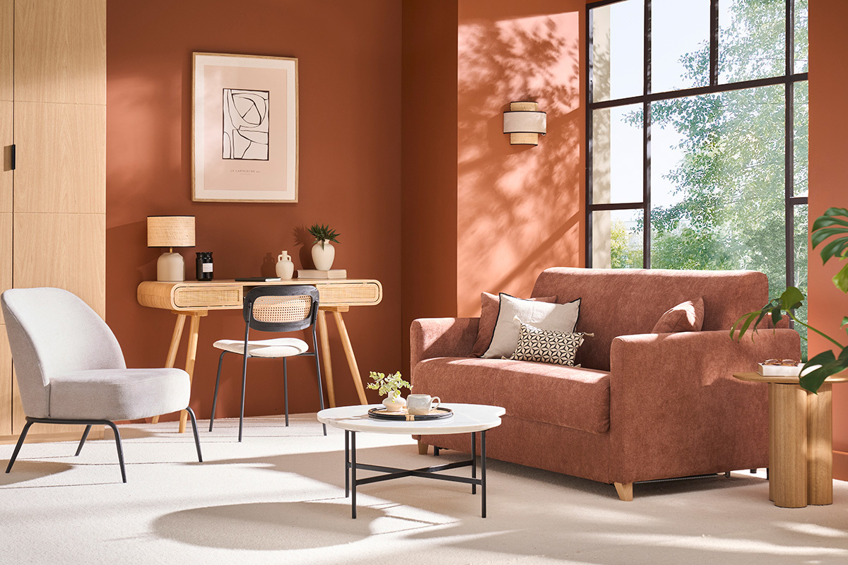 Sof convertible en tela color tierra quemada en un saln con escritorio y silln.