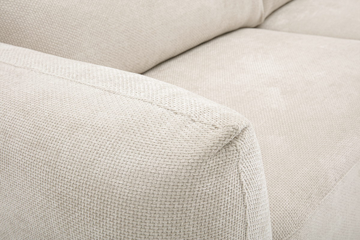 Primer plano del reposabrazos de un sof� de tela de terciopelo chenilla beige.