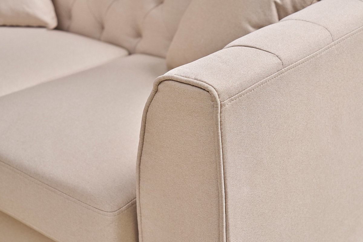 Primer plano del reposabrazos del sof de 2 plazas MONTAIGNE en tela beige con capiton.