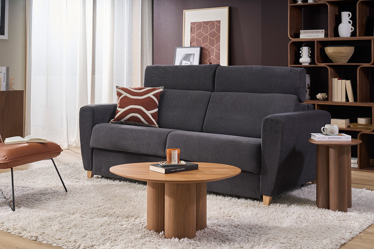 Sof� convertible de 3 plazas gris antracita con reposacabezas ajustables, vista frontal, decorado con mesa y coj�n.