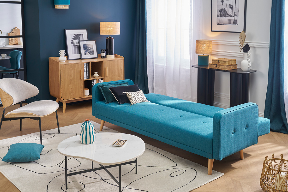 Sof� cama escandinavo azul y madera clara en modo cama en un sal�n moderno.