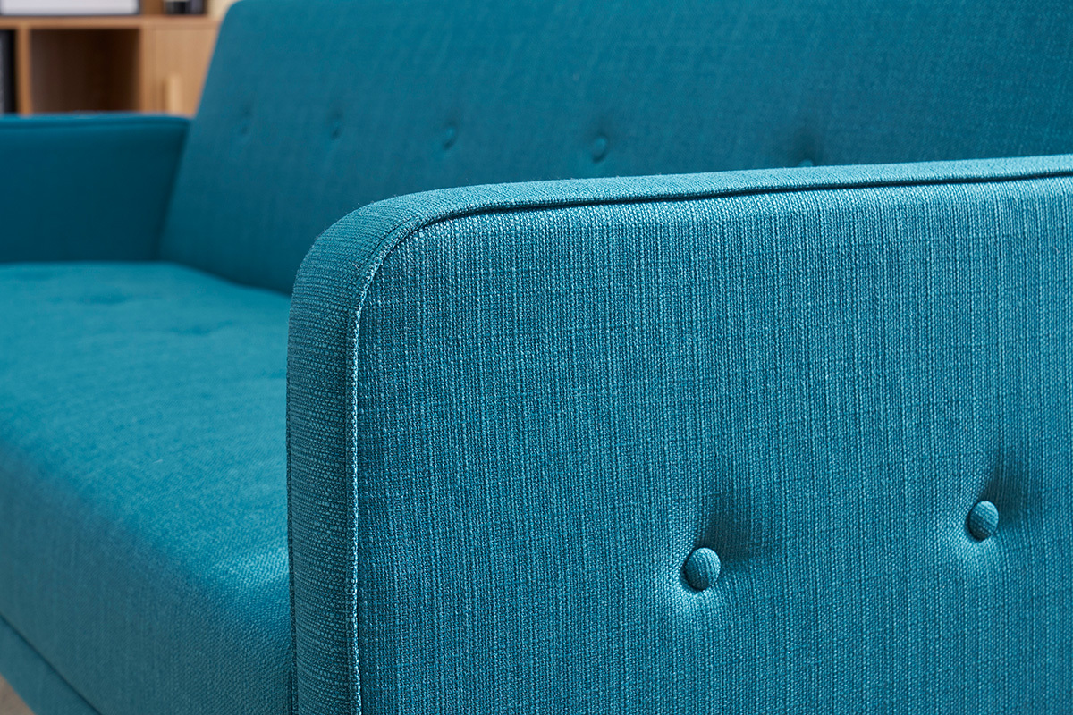 Detalle del brazo y respaldo del sof� cama azul de tela, vista en primer plano.