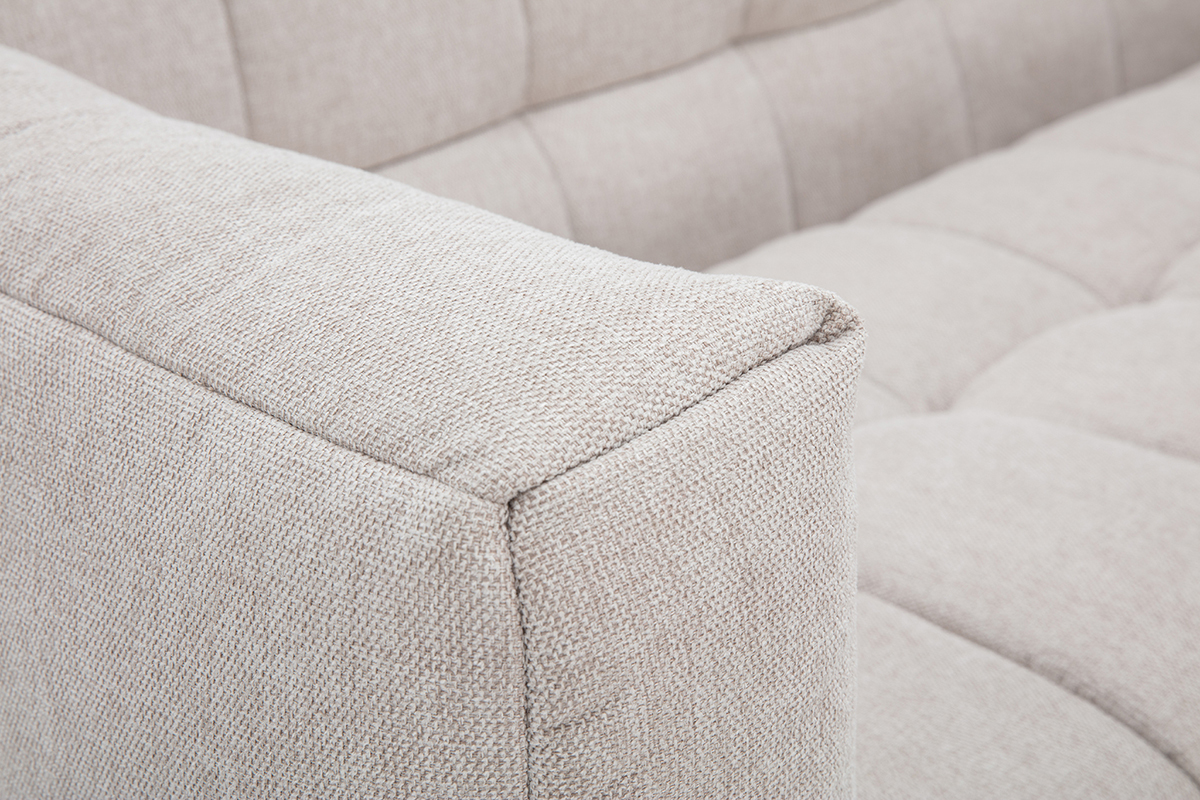 Vista cercana de un sof� beige de tela con efecto terciopelo texturizado.