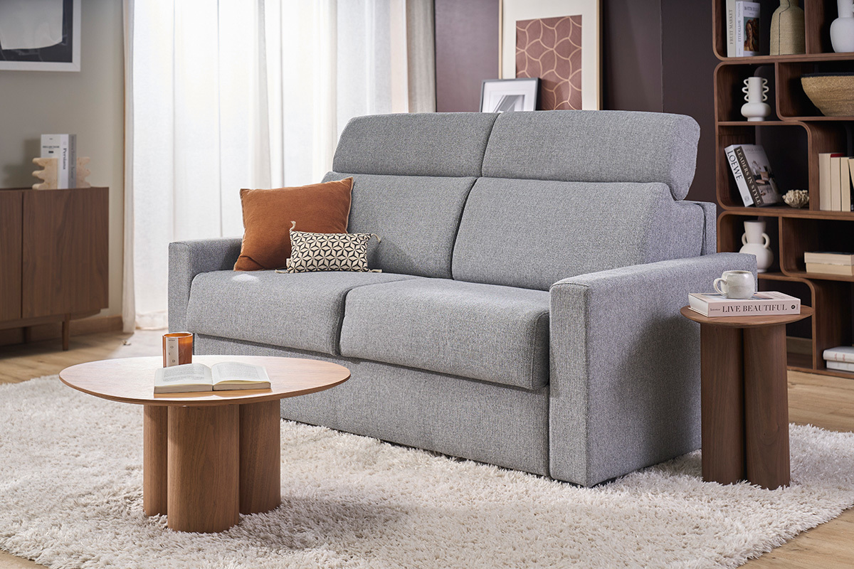 Sof� convertible NORO de 3 plazas gris claro con reposacabezas ajustables, vista frontal en una sala de estar moderna.