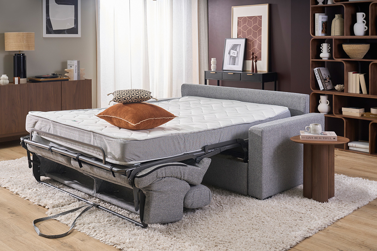 Sof� convertible NORO en tela gris claro, colch�n desplegado, reposacabezas ajustables, vista lateral.