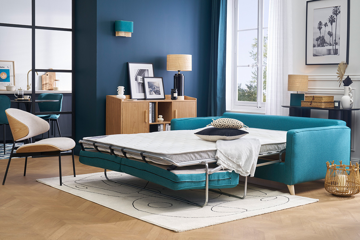 Sof� cama escandinavo en azul petr�leo, colch�n desplegado, vista de interior moderno.