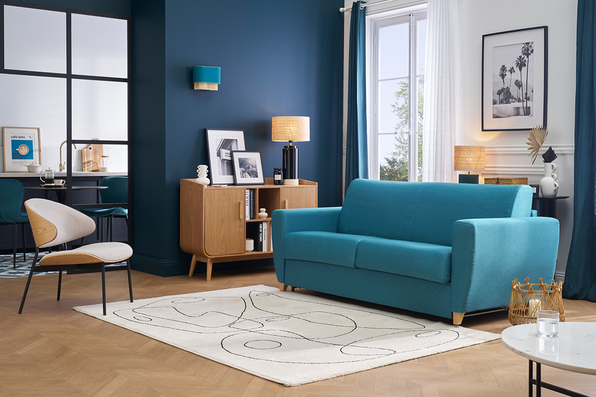 Sof� cama azul petr�leo de 3 plazas, vista frontal, en un sal�n moderno.