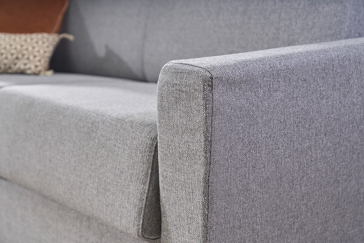 Detalle del sof� cama GRAHAM en tejido gris claro, vista de cerca del brazo y del asiento.