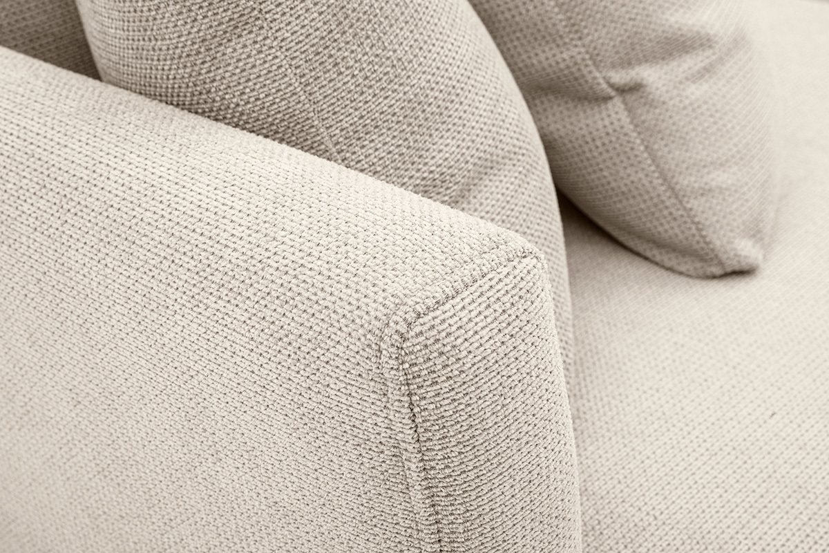 Detalle del sof� de 3 plazas en tejido chenilla beige con cojines desenfundables, �ngulo cercano