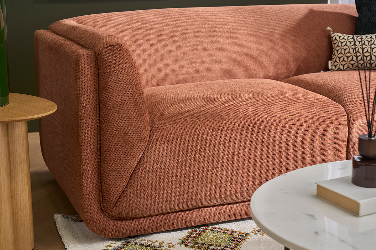 Sof� de 3 plazas de tela de chenilla en color tierra quemada, vista lateral, mesa de madera a la izquierda.