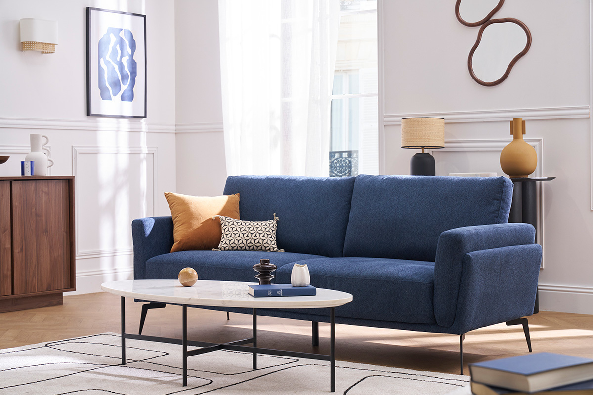 Canap� de dise�o de 3 plazas en tejido texturizado azul con cojines decorativos, vista general en una sala de estar.