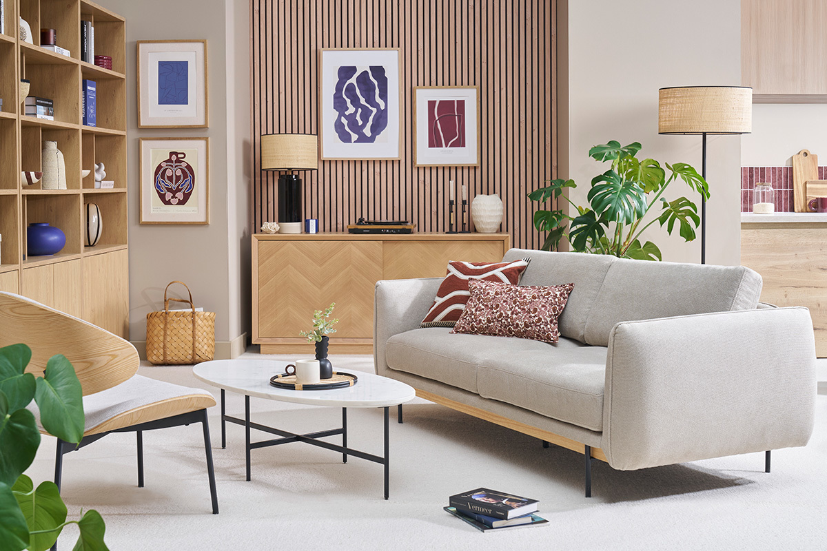 Sof� de dise�o de 3 plazas en tejido beige con cojines, vista frontal en un sal�n moderno.