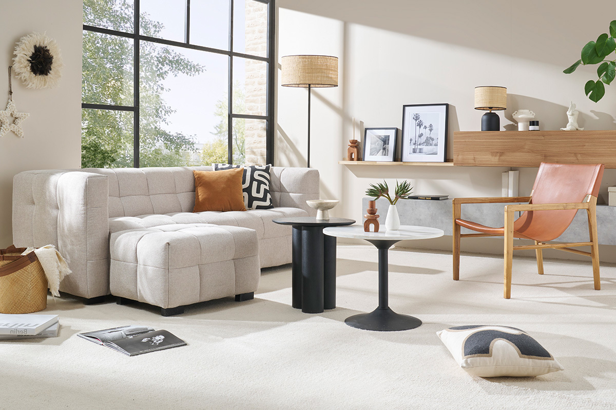 Sal�n con sof� de tela beige, l�mpara de pie, mesa baja y sill�n de cuero.