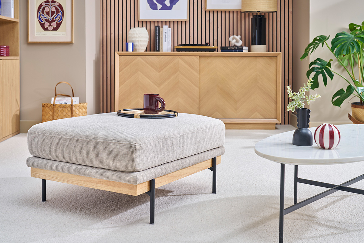 Reposapi�s de tela chenilla beige y metal negro en un sal�n elegante.