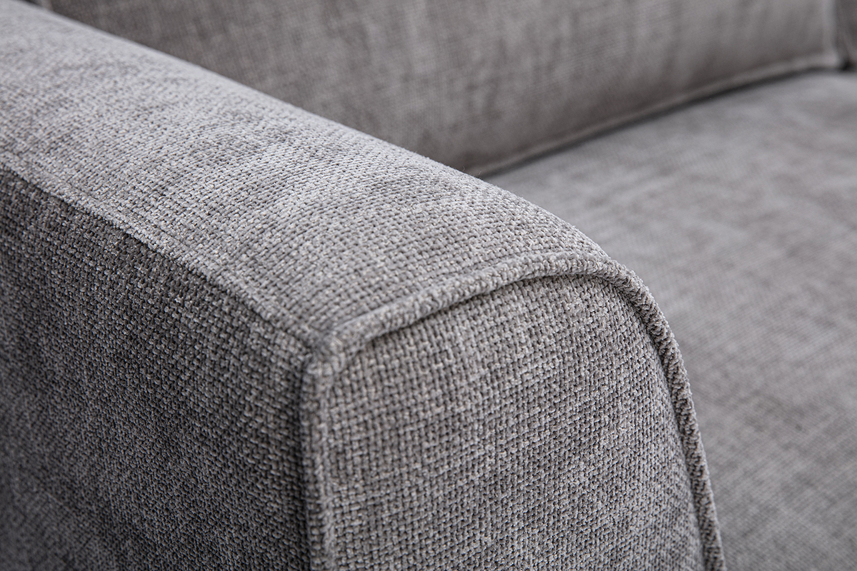 Detalle del sof� de dise�o de 3 plazas en tejido con efecto terciopelo texturizado gris, reposabrazos curvado