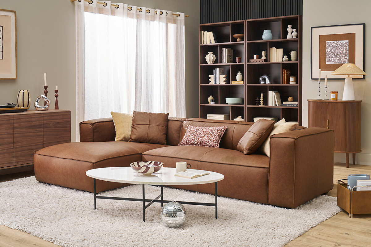 Sof de esquina de cuero marrn y madera negra con mesa baja, interior moderno.