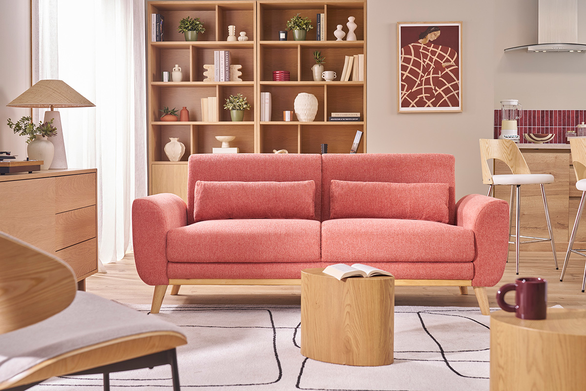 Sof� escandinavo de tres plazas y mesa cil�ndrica de madera en un sal�n moderno.