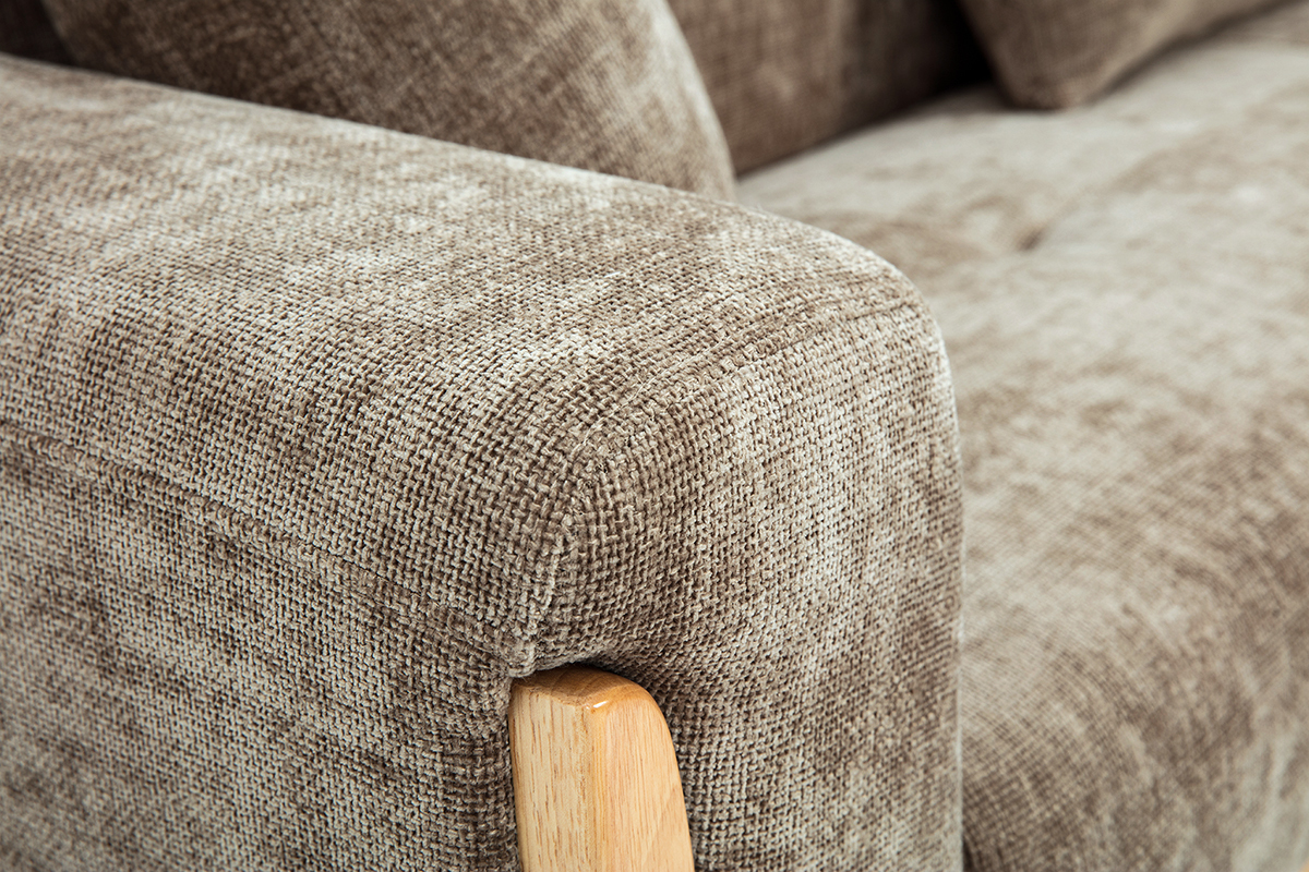 Primer plano del reposabrazos de sof� escandinavo efecto terciopelo topo y madera clara.