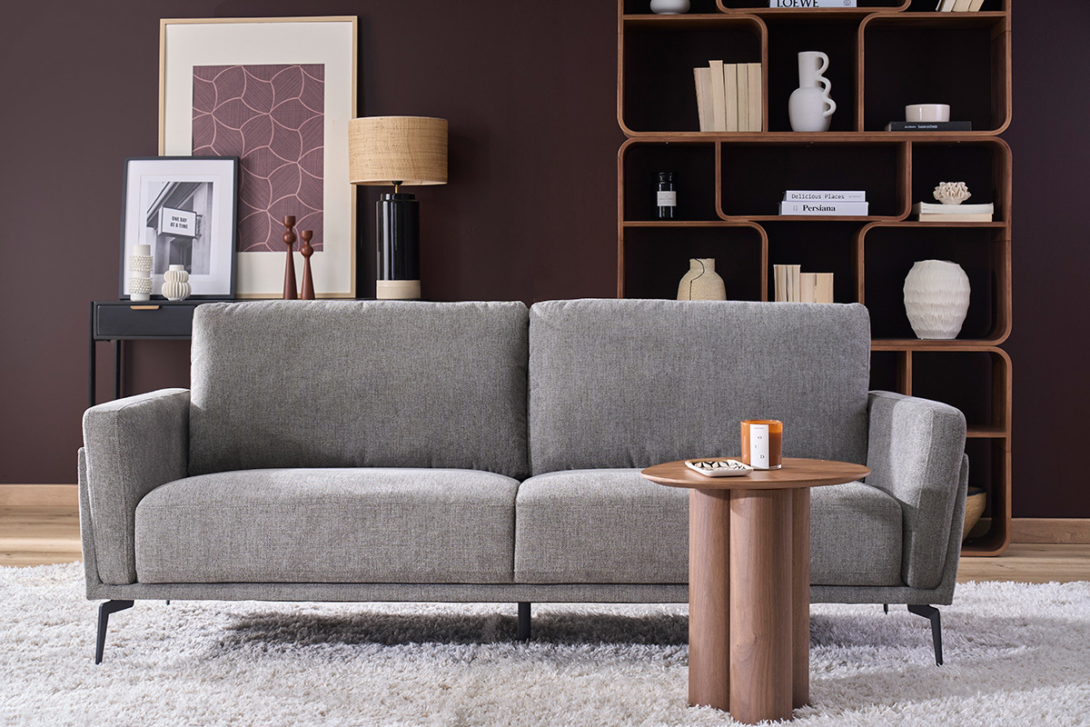 Sof� de dise�o de 3 plazas en tejido terciopelo gris, vista frontal con mesa decorativa